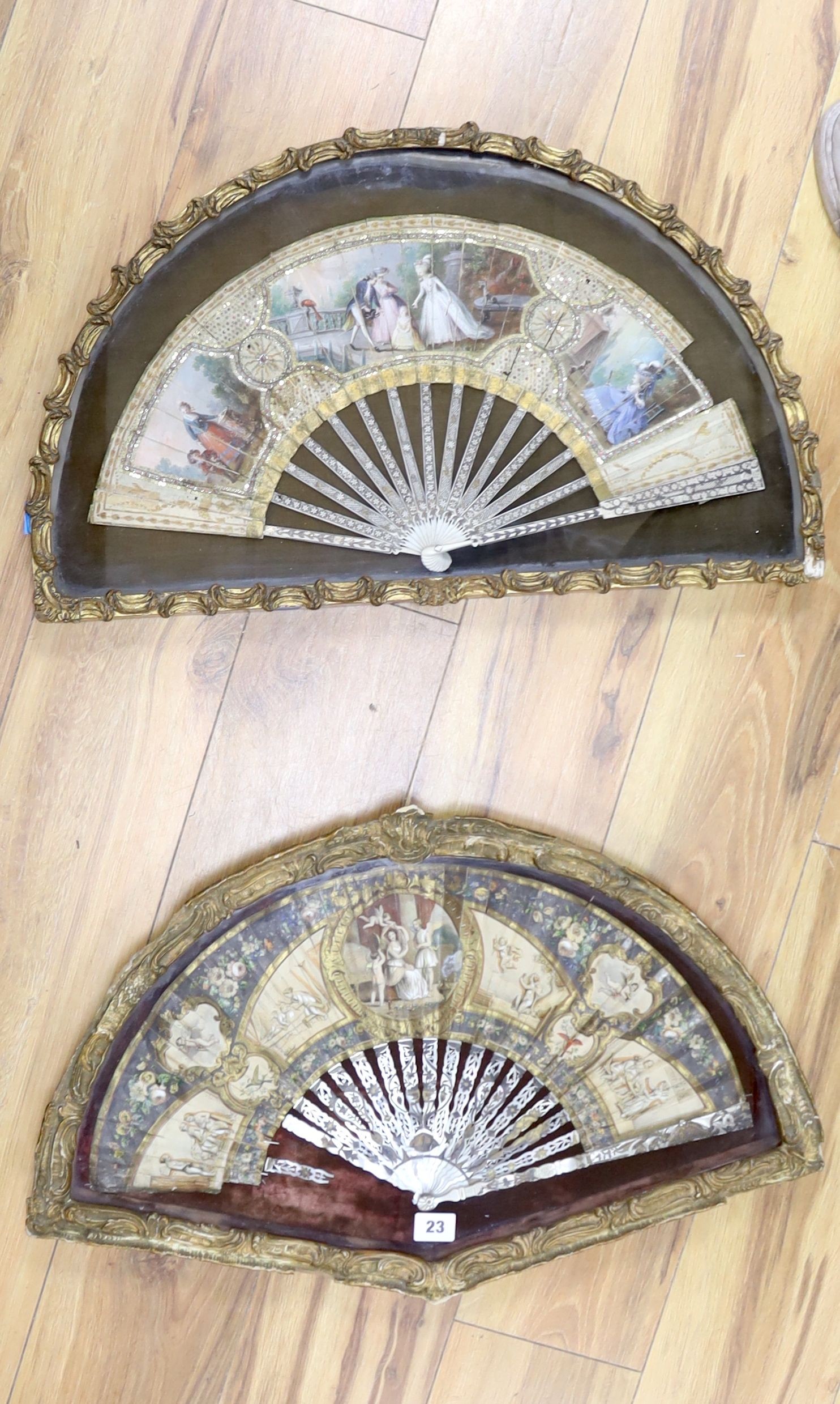 TO BE COLLECTED BY VENDOR Two late 18th/19th century French gesso framed fans with mother of pearl inlaid ivory sticks and guards with hand painted cartouche of classical figures and landscape on the fan leaves, length o
